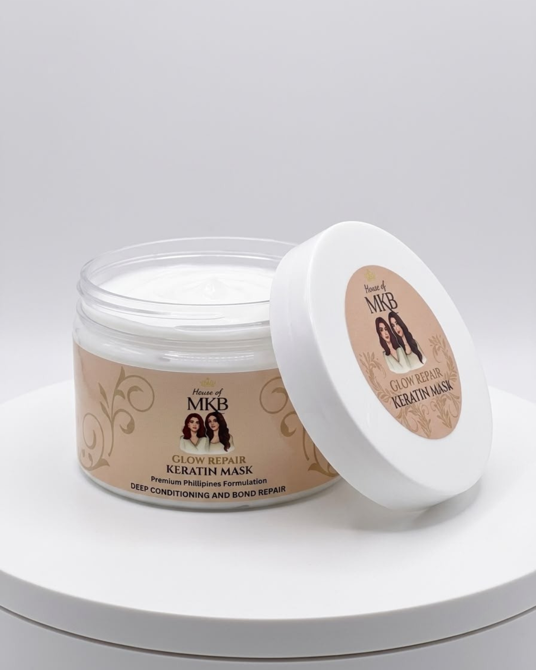House of MKB Glow Repair Keratin Hair Mask jar on a premium marble studio surface with gold comb and argan oil capsules.